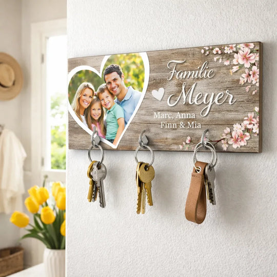 Personalisiertes Schlüsselbrett in Holzoptik mit Familienfoto und Namen, an der Wand befestigt mit Schlüsseln an vier Haken.