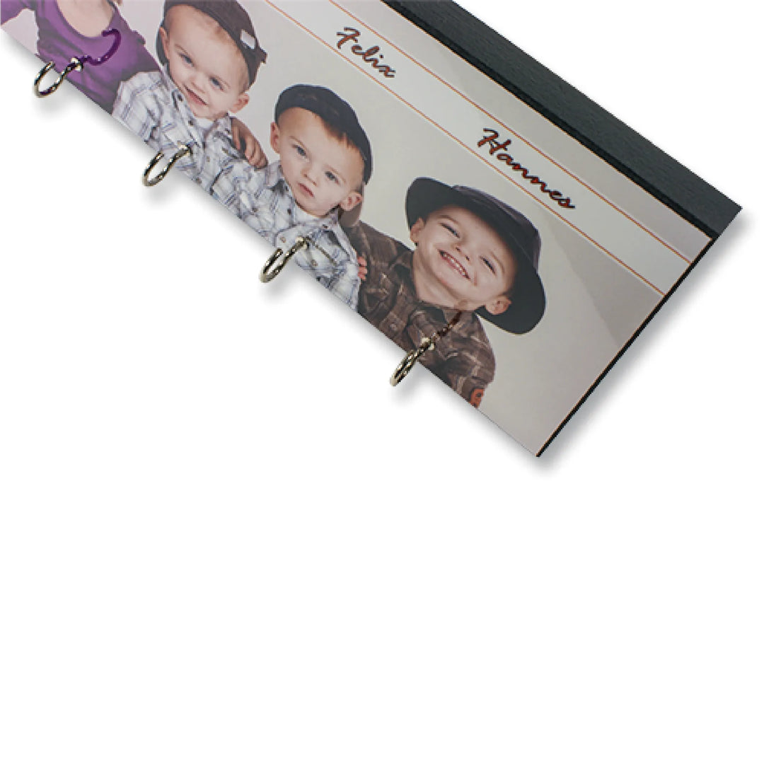 Personalisiertes Schlüsselbrett mit Fotodesign von Kindern und mehreren Schlüsselhaken, Detailaufnahme aus schräger Perspektive.