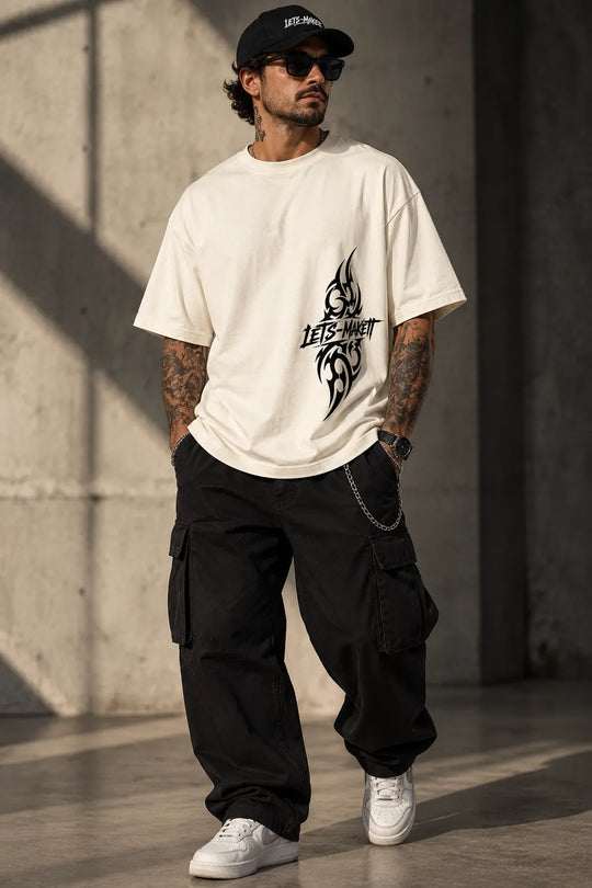 Mann trägt Tribal Streetwear Oversize T-Shirt in Coconut Milk mit schwarzem Frontprint